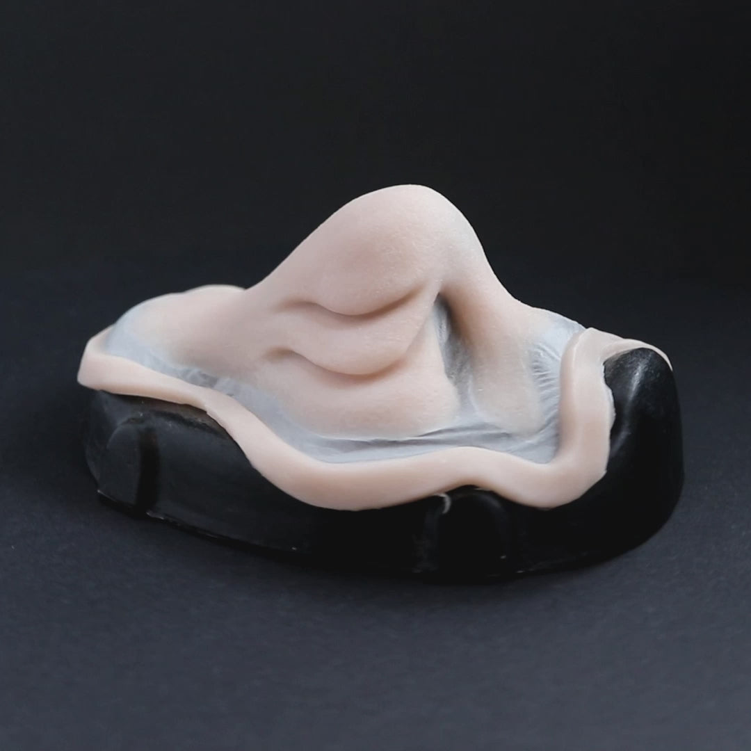 Manta nose prosthetic in vanilla shade on a black turntable, slowly rotating. 