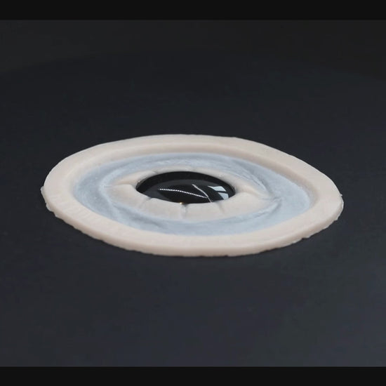 Black gem prosthetic in vanilla shade on a black turntable, slowly rotating. 