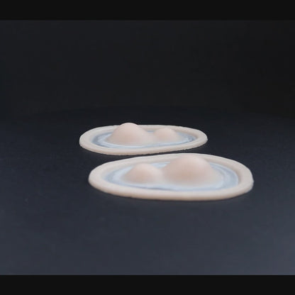 A pair of double subdermal horn prosthetics in vanilla shade on a black turntable, slowly rotating. 