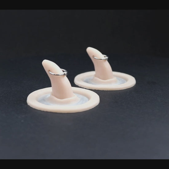 Pierced horns prosthetics in vanilla shade on a black turntable, slowly rotating. 