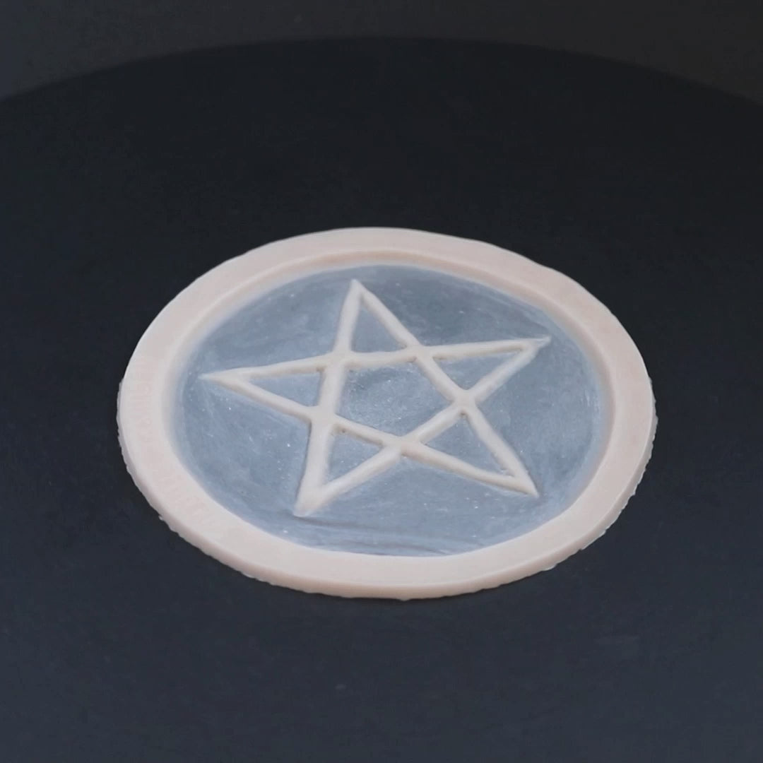 Pentagram prosthetic in vanilla shade on a black turntable, slowly rotating. 