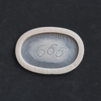 666 carving prosthetic in vanilla shade on a black surface