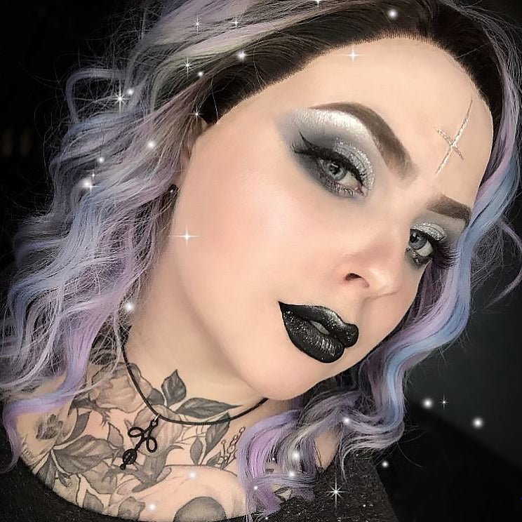 Woman in pastel lilac hair wearing a cross carving in vanilla shade and lilac makeup