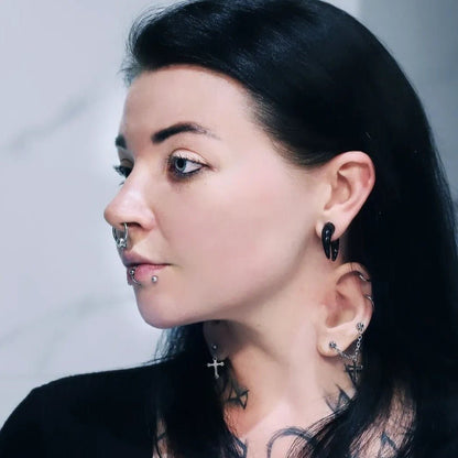 Woman with black hair wearing an extra ear on her neck