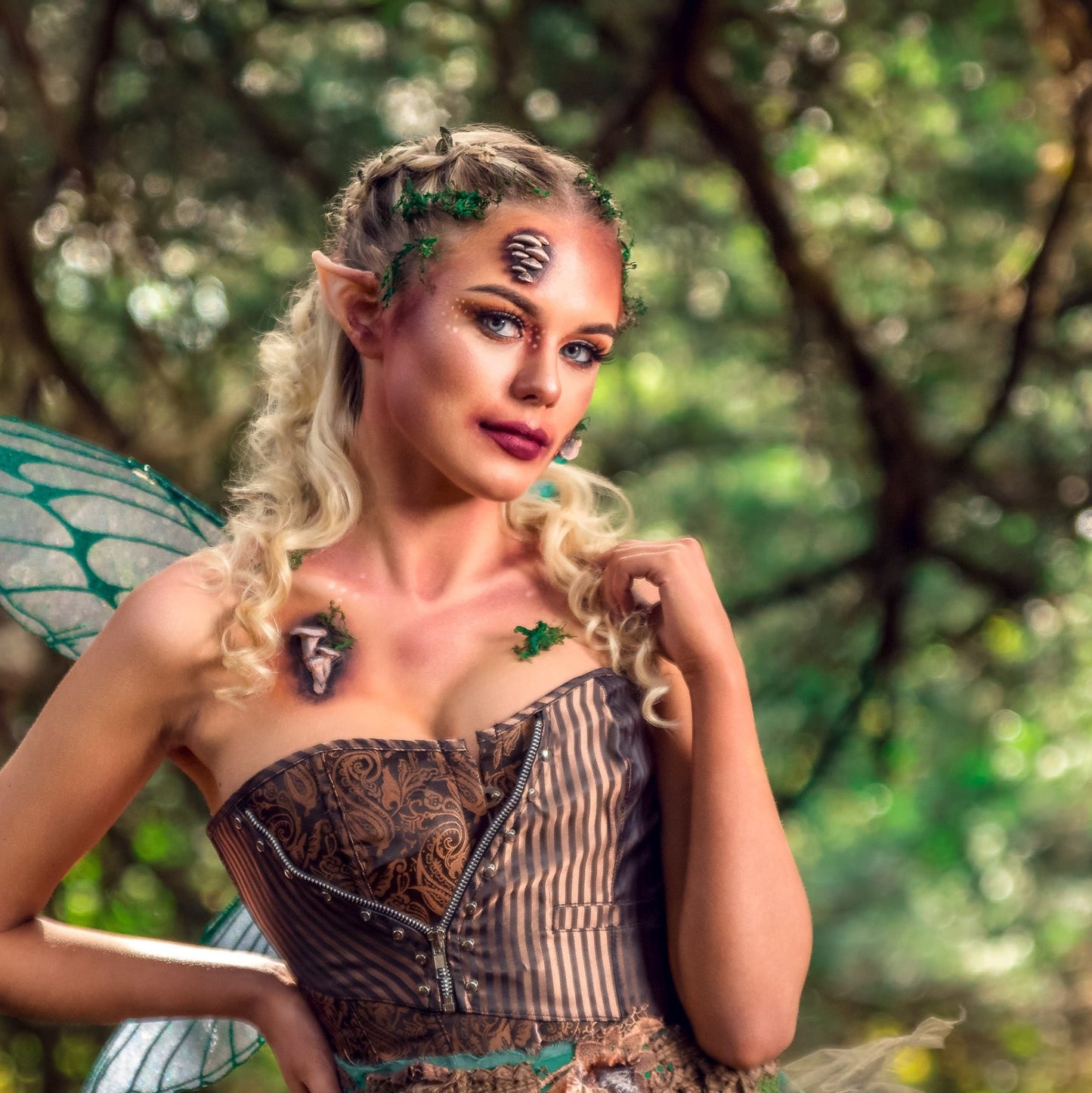 Blond woman dressed as a fairy with fungi prosthetics on her face and chest