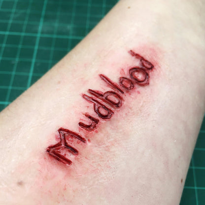 Arm with a bloody Mudblood carving on it