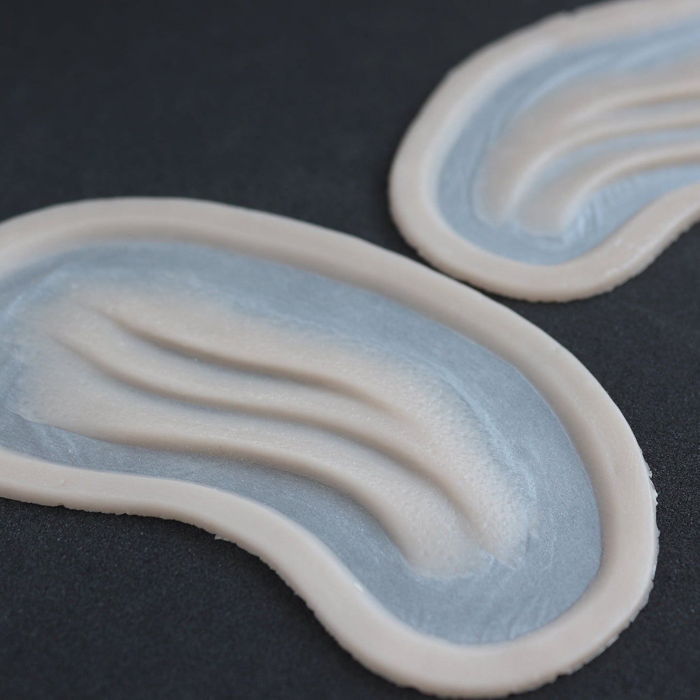 Manta Gills (Pair) - Silicone makeup prosthetic in vanilla shade on a black surface