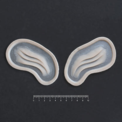Manta Gills (Pair) - Silicone makeup prosthetic in vanilla shade on a black surface with a ruler
