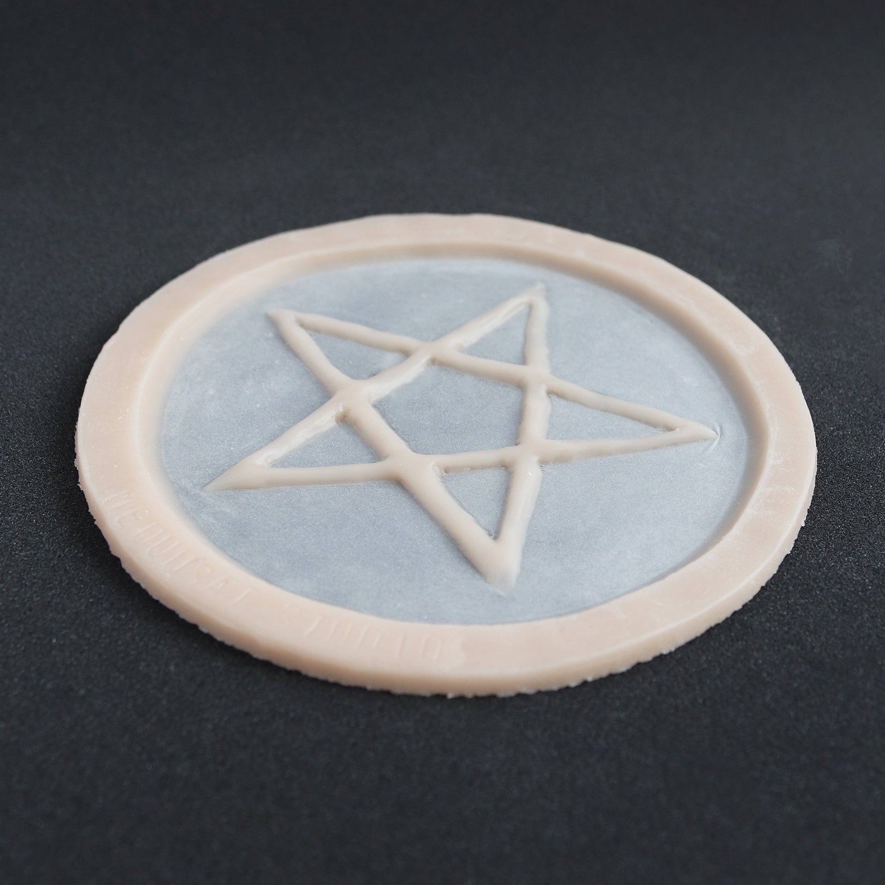Pentagram Scarification - Silicone makeup prosthetic in vanilla shade on a black surface