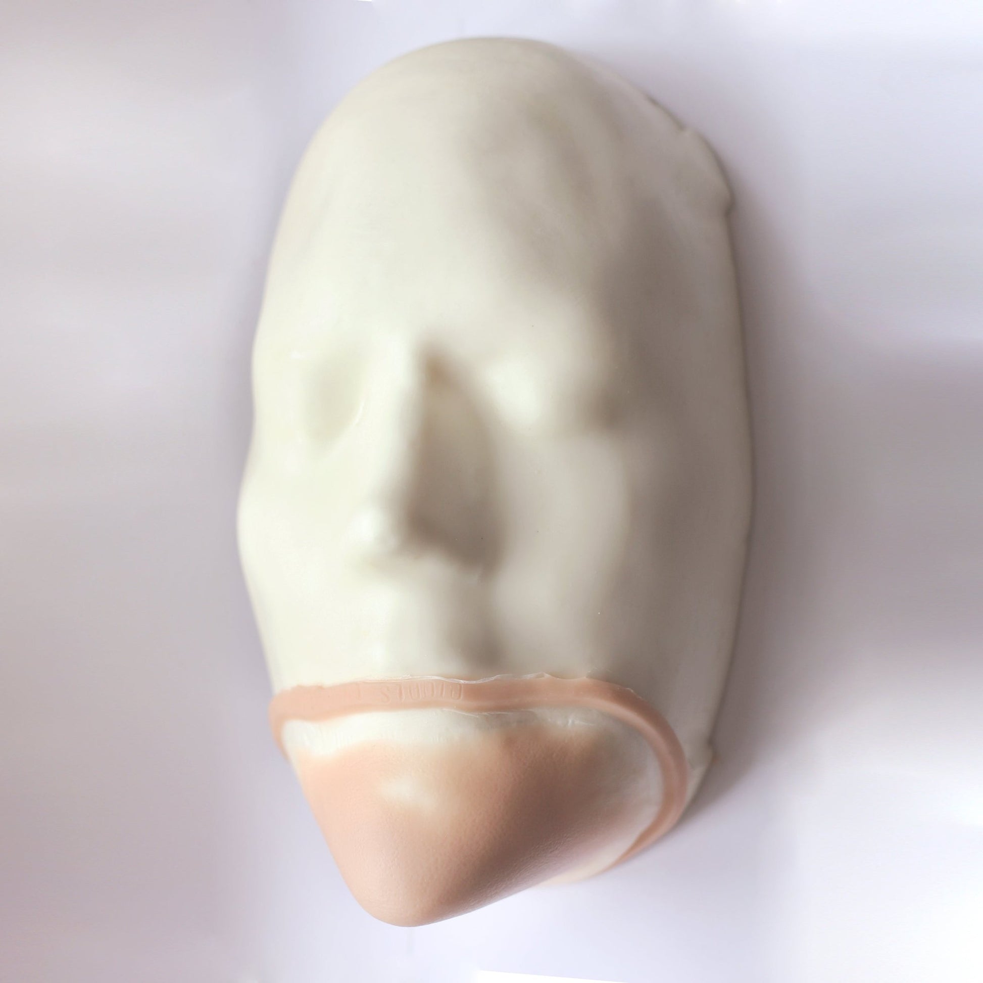 Pointy Chin - Silicone makeup prosthetic in vanilla shade on a white surface