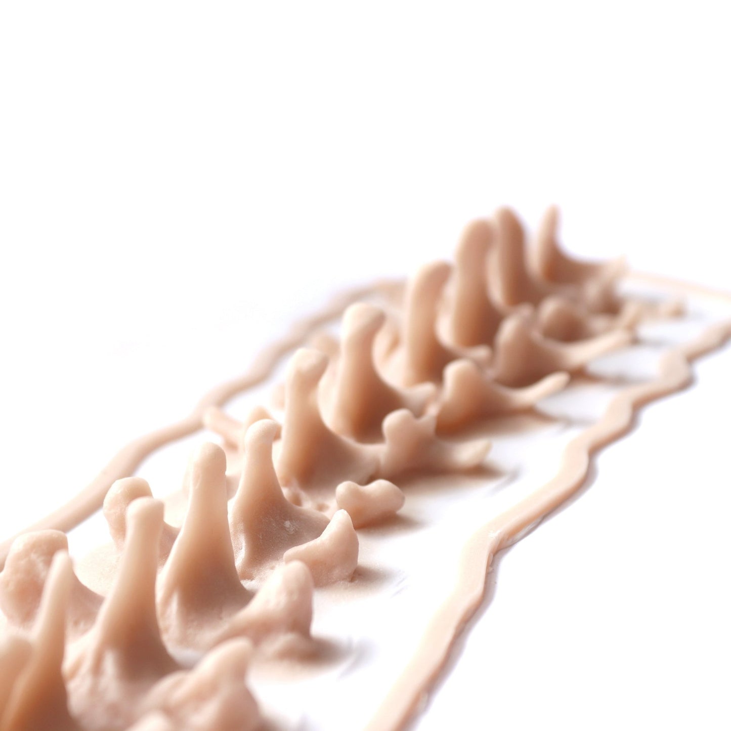 Protruding Spine (Lifesize) - Silicone makeup prosthetic in vanilla shade on a white surface