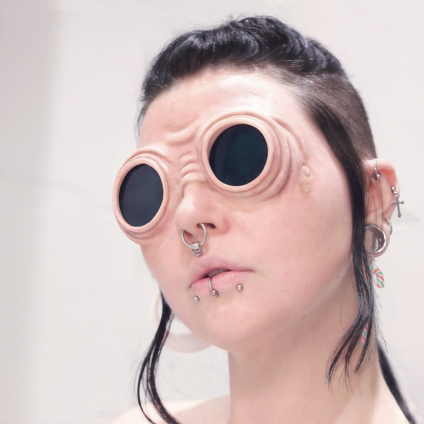 Woman with a black braid wearing goggles prosthetics