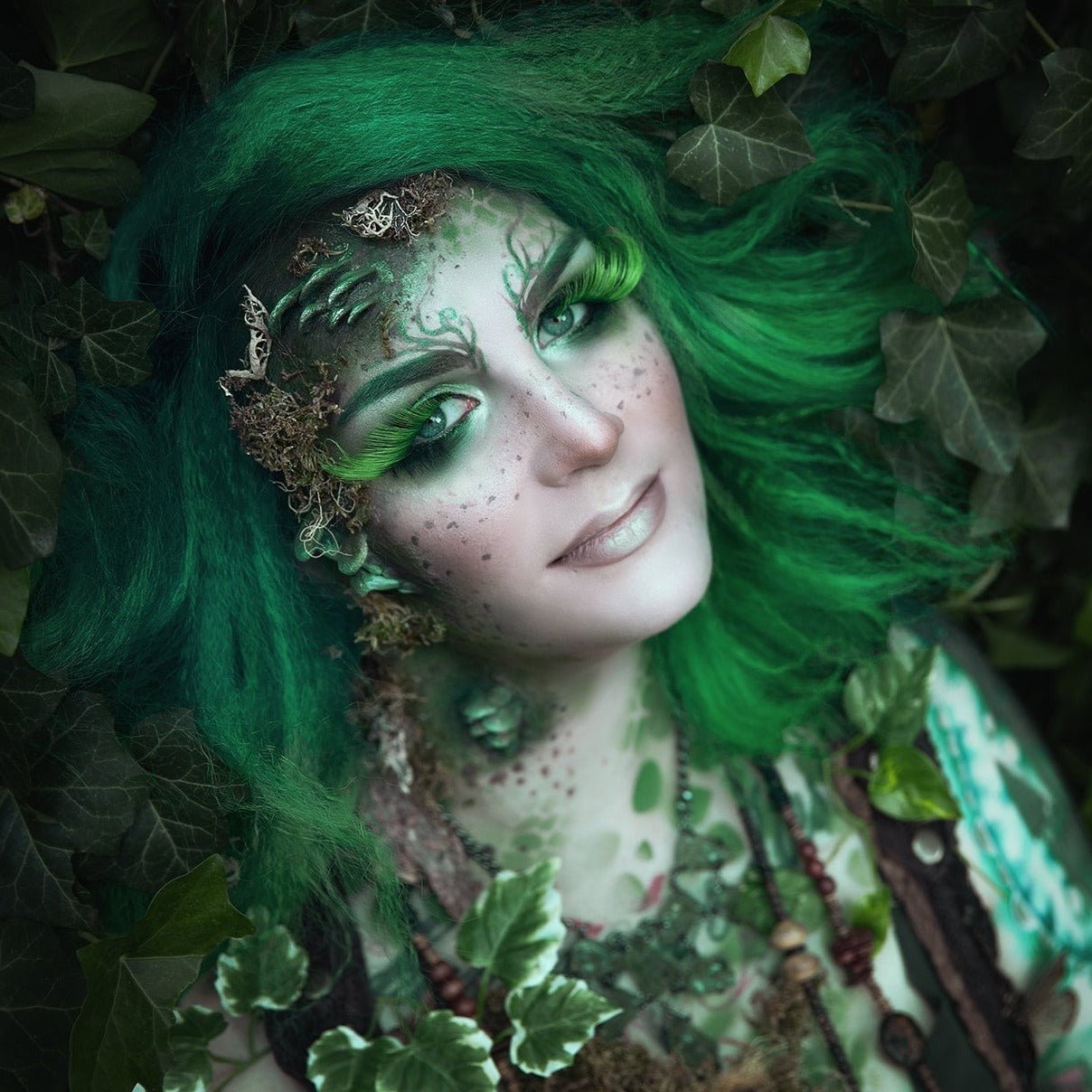 Woman with green hair wearing fungi prosthetics on her face